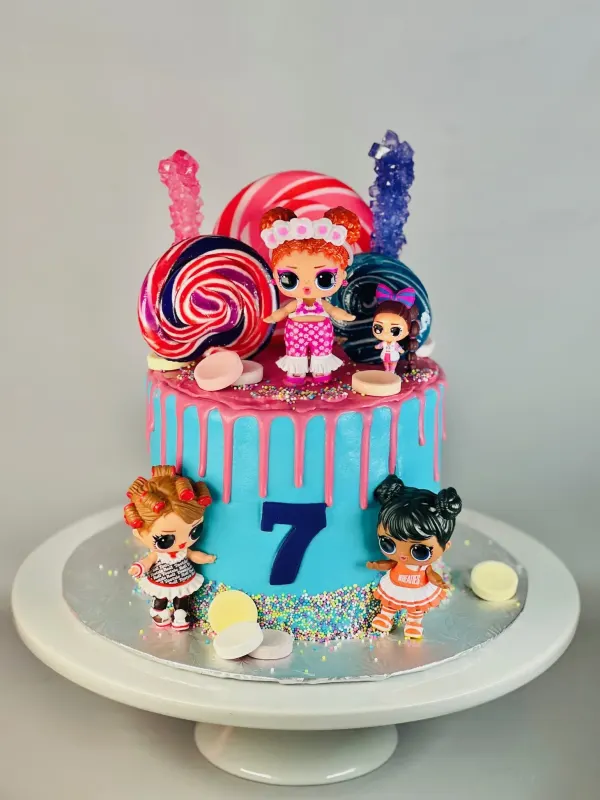 LOL Surprise doll cake in blue with pink drip, lollipops, rock candy and the number 7