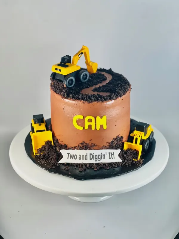 Construction cake with toy diggers, cookie-crumb dirt, CAM and a Two and Diggin' It banner