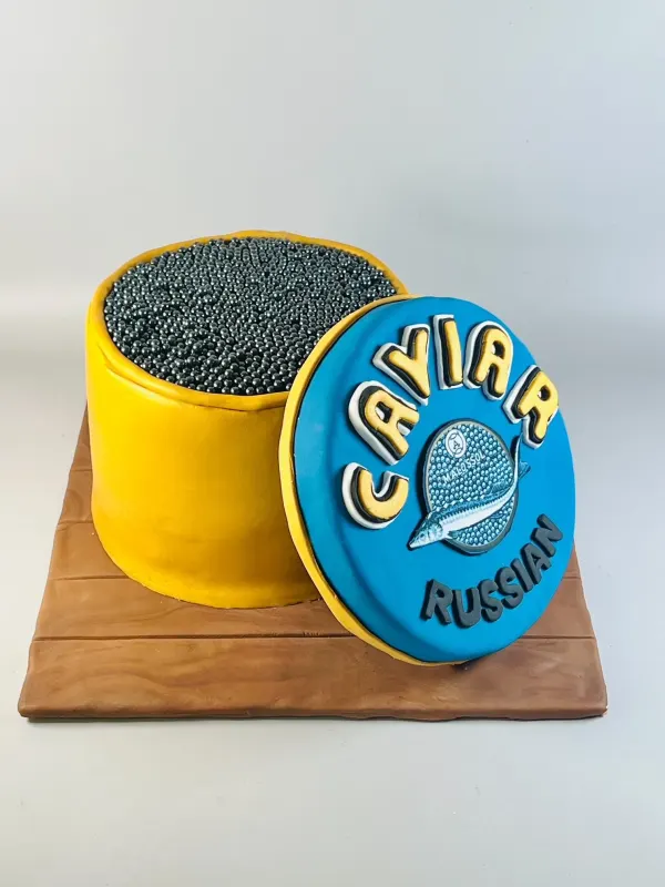 Cake shaped like an open tin of Russian caviar with sugar pearls and a blue fondant lid