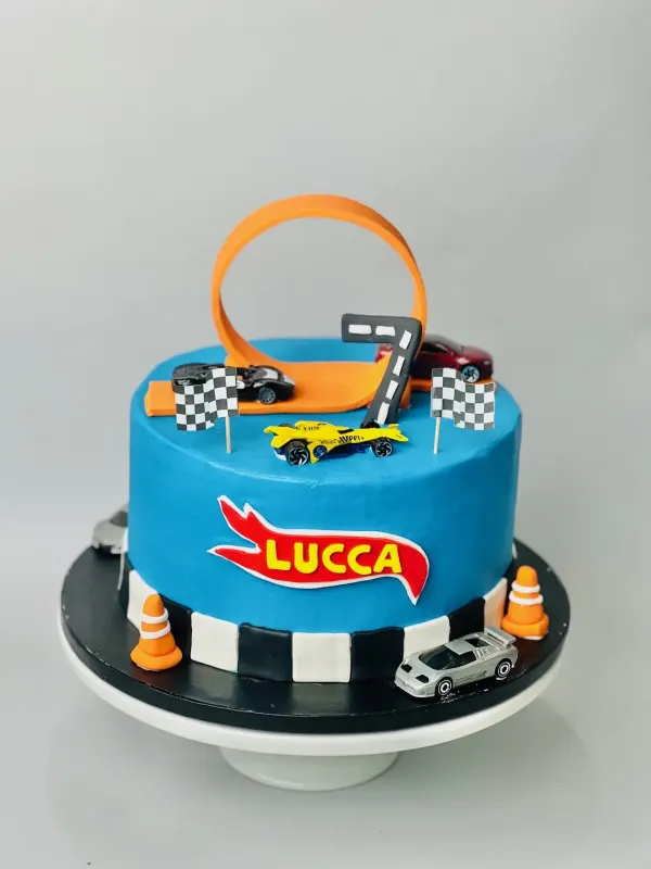 Hot Wheels birthday cake with the name Lucca, an orange loop track, toy cars and a fondant number 7
