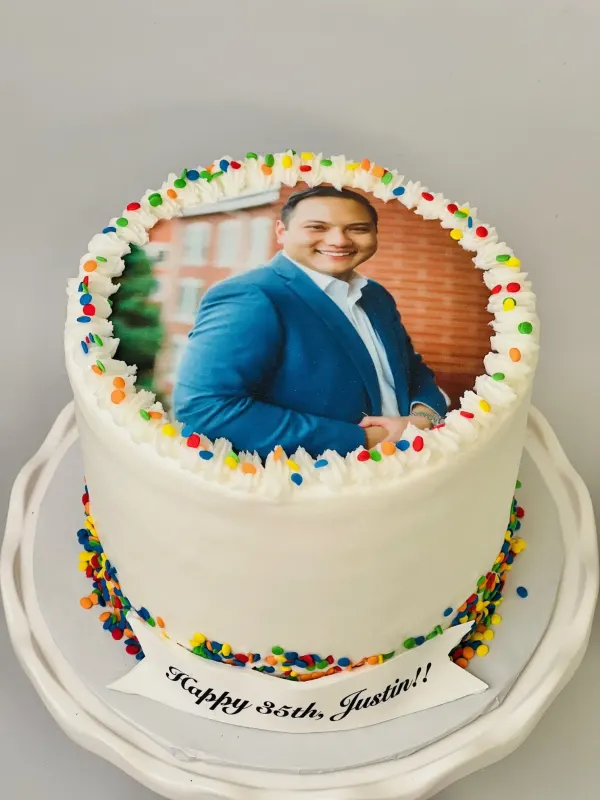 Photo birthday cake with a printed portrait, rainbow sprinkles and a Happy 35th, Justin banner