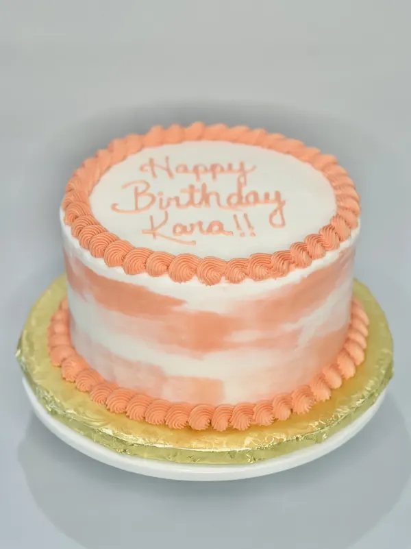 Peach and white striped buttercream cake with piped shell borders and Happy Birthday Kara
