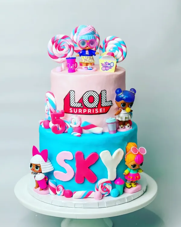 Two-tier L.O.L. Surprise birthday cake with doll figures, fondant lollipops and the name Sky