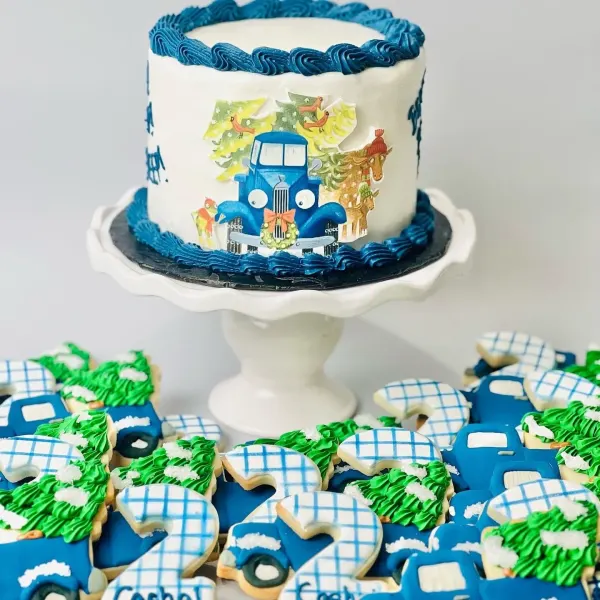 Little Blue Truck birthday cake with blue piped borders and matching truck, tree and number 2 cookies