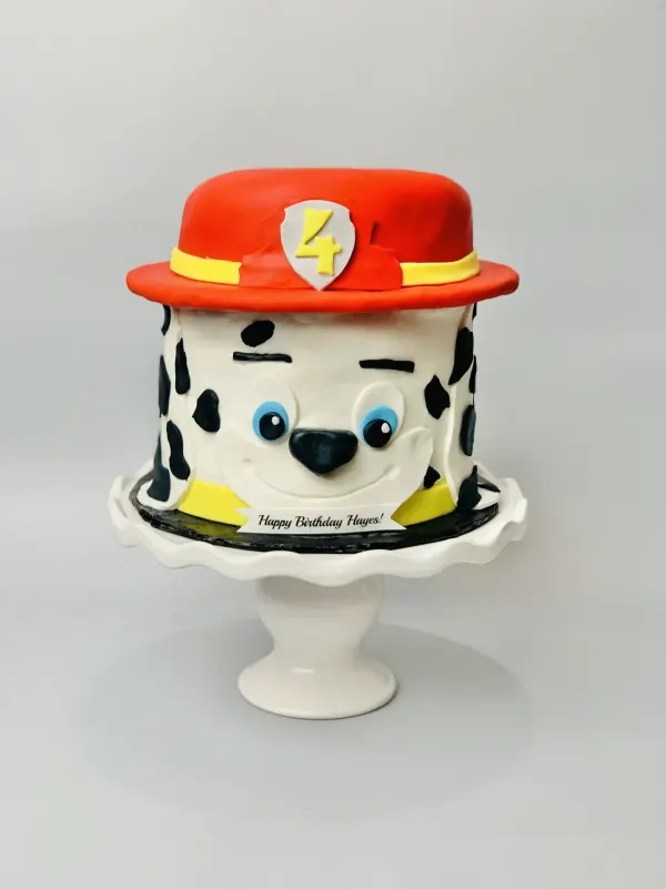 Paw Patrol Marshall dalmatian cake with a red fire hat marked 4 and Happy Birthday Hayes