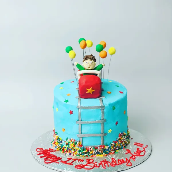 Blue roller coaster cake with a fondant rider, balloon toppers and Happy 17th Birthday piped in red