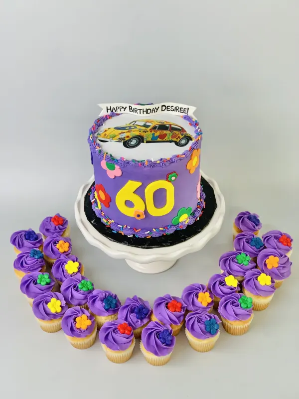 Purple 60th birthday cake with a flower-power VW Beetle image and matching purple rosette cupcakes