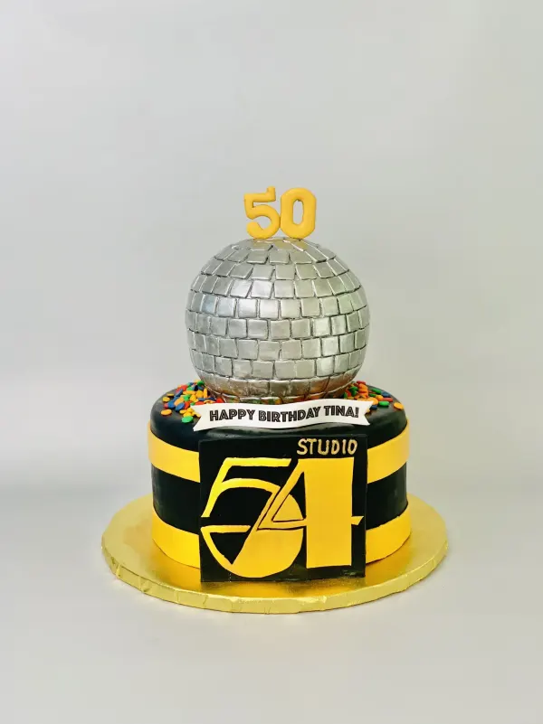 Studio 54 disco cake with a silver mirror-ball topper, gold 50 and Happy Birthday Tina banner