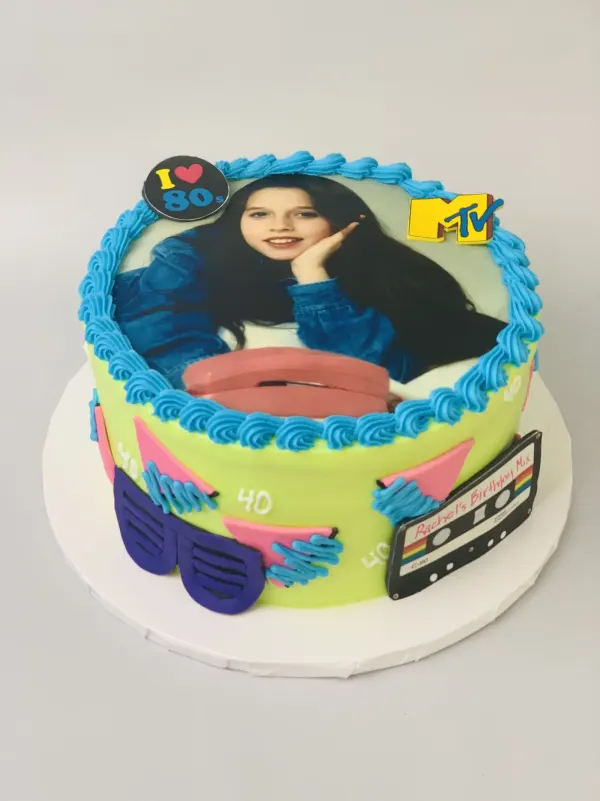 1980s 40th birthday photo cake with an MTV logo, neon shutter shades and a cassette-tape plaque