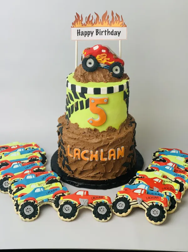 Two-tier monster truck cake with chocolate mud, an orange 5 and Lachlan monster truck cookies