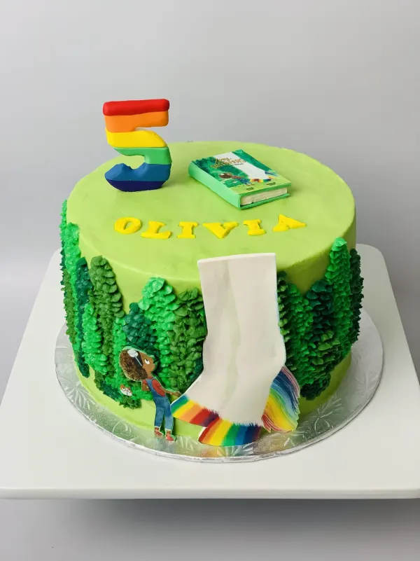 Green forest birthday cake with a Zoey and Sassafras book topper, rainbow number 5 and the name Olivia