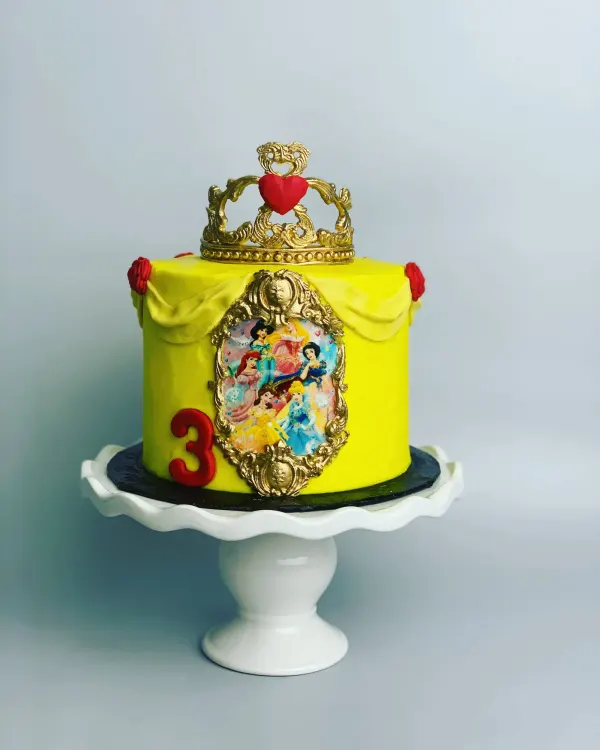 Yellow princess birthday cake with a gold crown topper, Disney princess image panel and red number 3