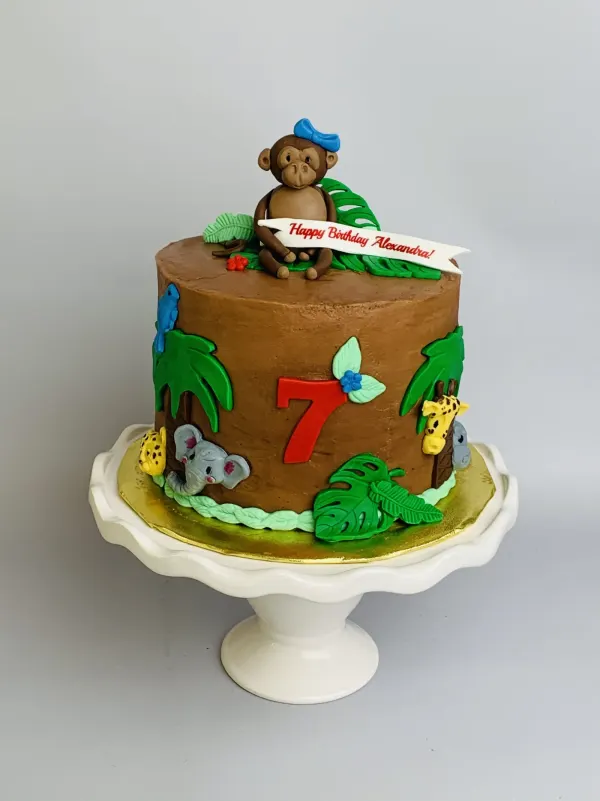 Jungle birthday cake in chocolate buttercream with a monkey topper, animals and Happy Birthday Alexandra