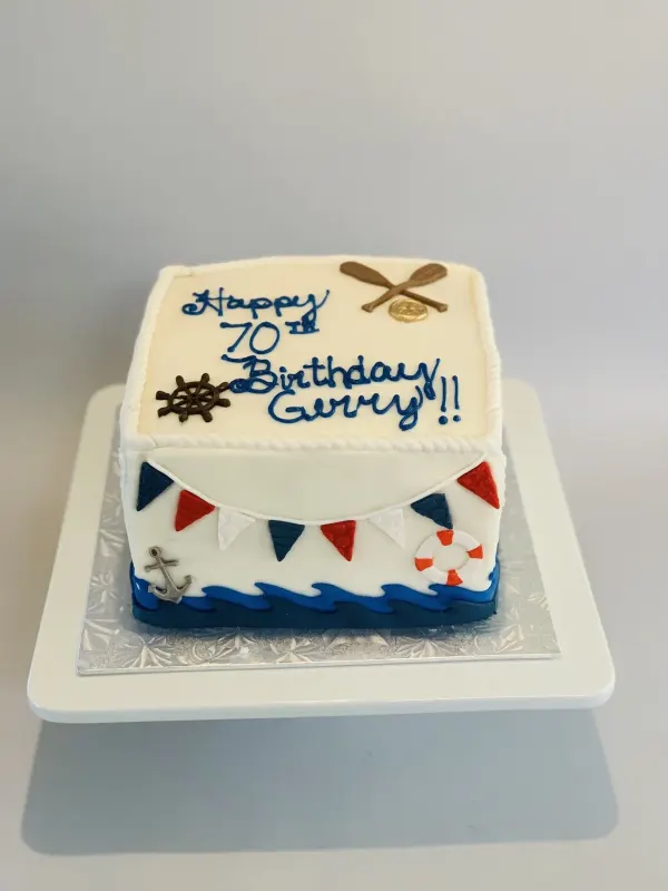 Nautical square cake with bunting, anchor, ship wheel, oars and Happy 70th Birthday Gerry