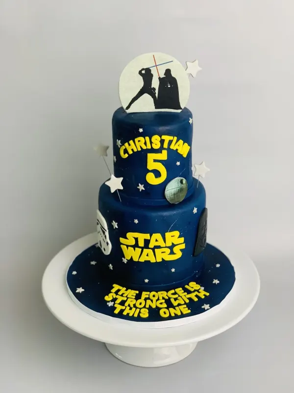 Two-tier navy Star Wars birthday cake reading Christian 5 and The Force Is Strong With This One
