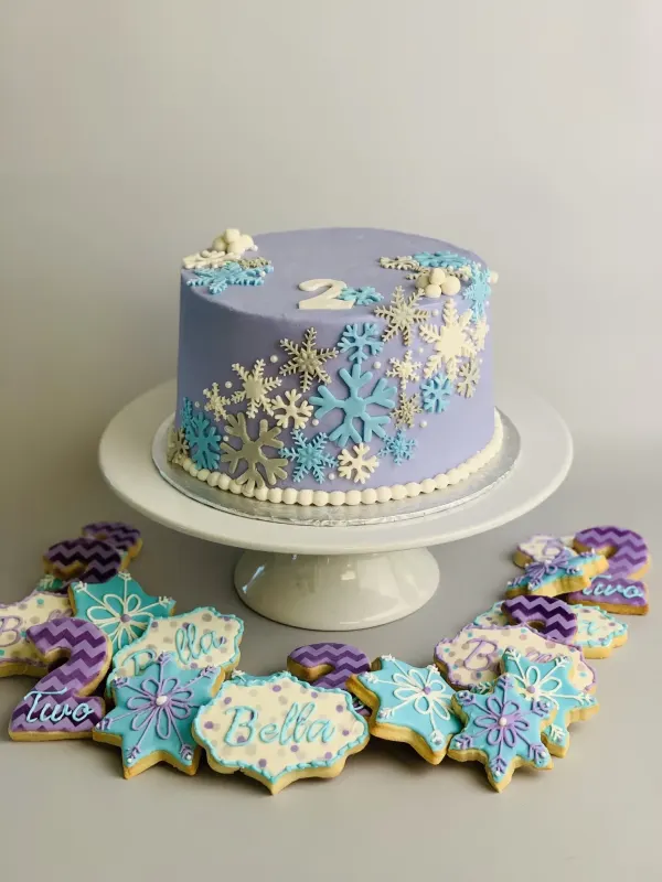 Purple snowflake second birthday cake with matching Bella and Two decorated sugar cookies