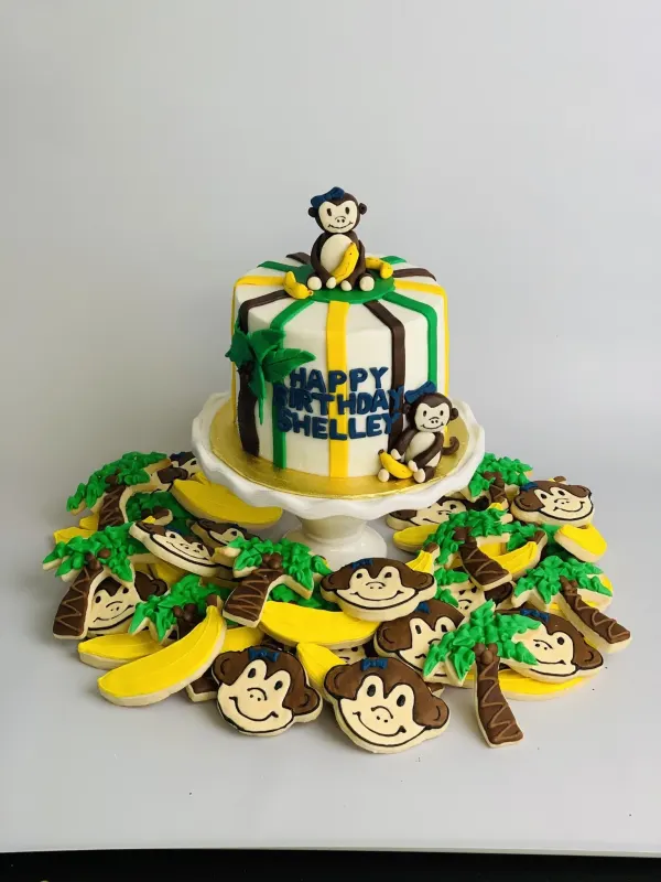 Monkey birthday cake reading Happy Birthday Shelley with monkey, banana and palm tree cookies