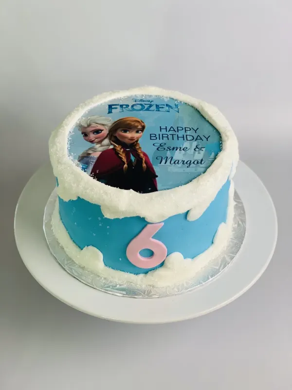 Frozen birthday cake with an Elsa and Anna photo topper, snow trim and a pink 6 for Esme and Margot