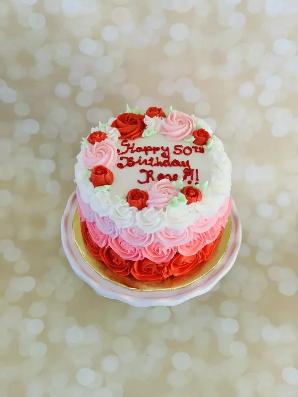 Pink and red ombre rosette cake piped with Happy 50th Birthday Rose