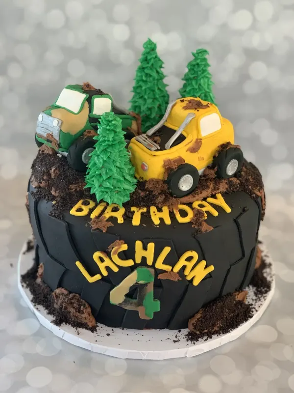 Off-road truck birthday cake reading Birthday Lachlan 4 with green and yellow trucks and cookie mud