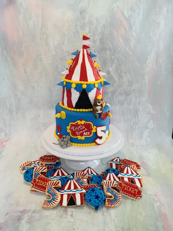 Circus big-top cake reading Riyah and Roman are 5 with a bear, elephant and matching tent cookies