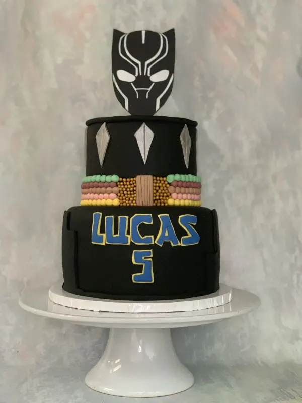 Two-tier Black Panther cake with a mask topper, beaded belt and Lucas 5 in blue lettering