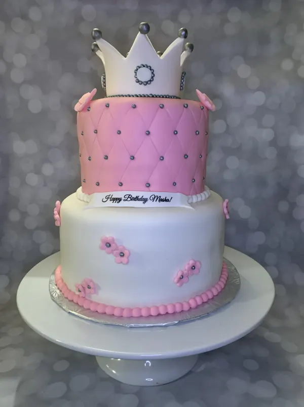 Two-tier pink princess cake with a fondant crown, quilted tier with silver dragees and Happy Birthday Masha