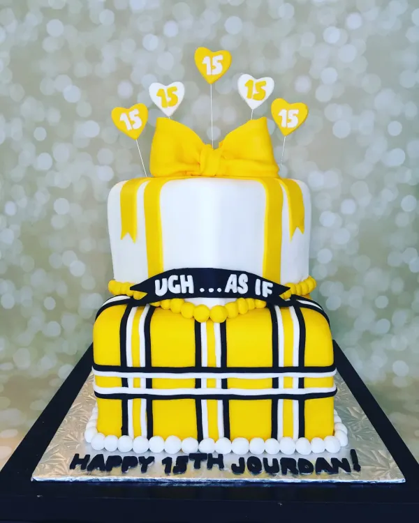 Two-tier yellow plaid cake with a fondant bow and Happy 15th Jourdan on the board