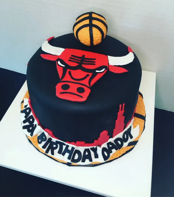 Chicago Bulls cake in black fondant with the bull logo, basketball topper and Happy Birthday Daddy