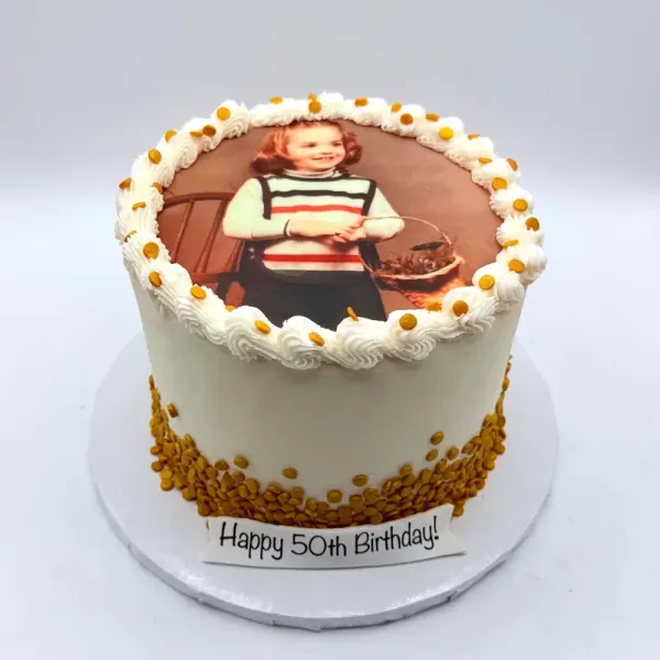 Cream cake with a sepia edible photo print, a piped border and a gold sprinkle base
