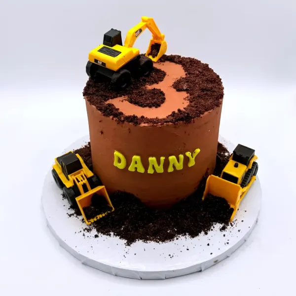 Chocolate construction cake with crumb dirt, a yellow excavator on top and diggers at the base
