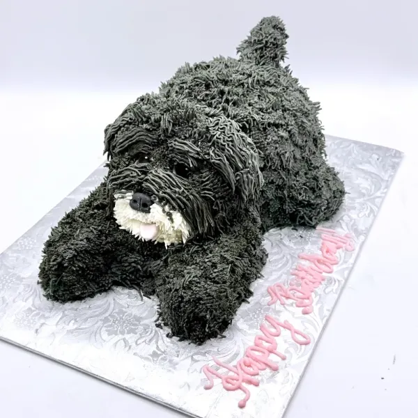 Sculpted dog cake with piped shaggy grey fur, lying on a silver board