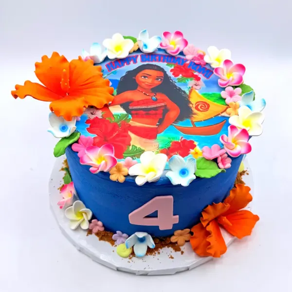 Blue cake with an edible Moana print, tropical sugar flowers in orange and pink and a number four