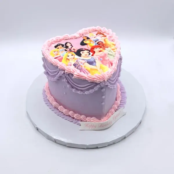 Lavender heart shaped cake with an edible print of princess characters and pink piped borders