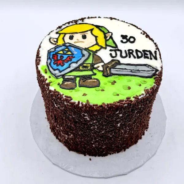 Cake coated in chocolate sprinkles with a hand painted game character on top, lettered 30 Jurden