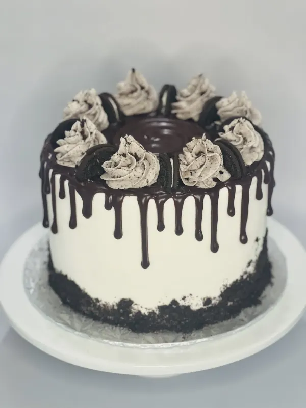 White buttercream cake with dark chocolate drip, cookies-and-cream swirls and Oreo halves