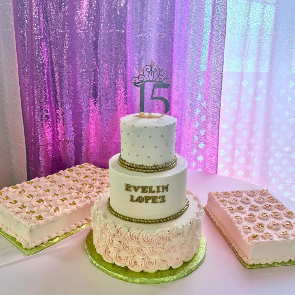 Two tier quinceañera cake with gold beading, buttercream rosettes and a 15 topper, with two sheet cakes