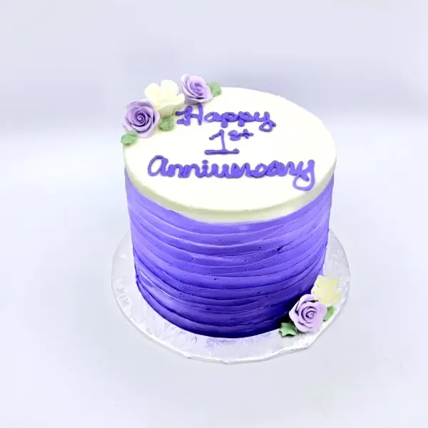 Single tier cake with lavender ombré buttercream, sugar roses, and Happy 1st Anniversary piped on top