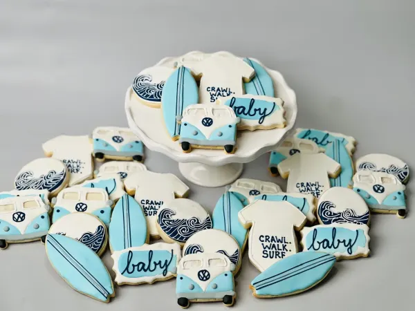 Blue surf baby shower cookies with VW buses, surfboards, waves and Crawl Walk Surf onesies