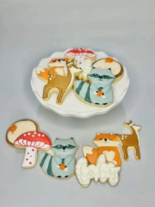 Woodland baby shower cookies with fox, deer, raccoon, red mushroom and baby in script