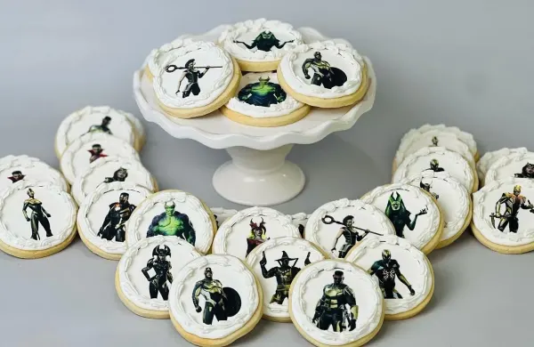 Round cookies with white piped borders and printed superhero character images