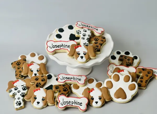 Puppy party cookies with dog faces, paw prints, number 1 and bones lettered Josephine