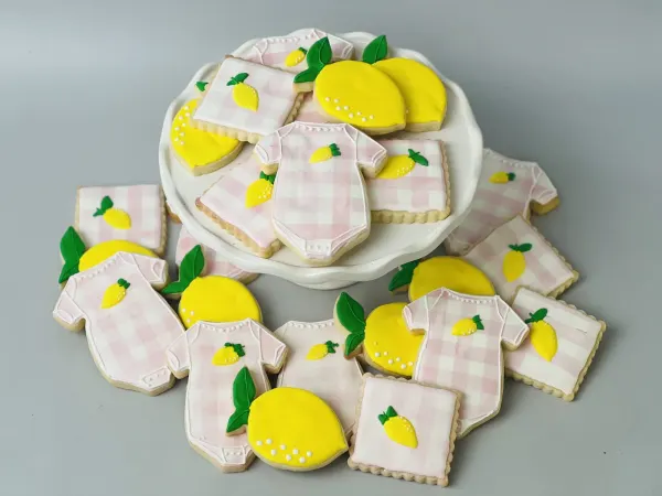 Set of cookies with pink gingham onesies, yellow lemons and pink gingham squares