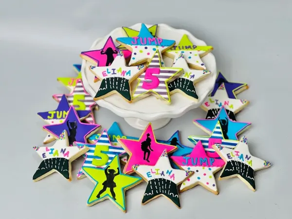 Neon star cookies with jumping silhouettes reading JUMP, ELIANA and the number 5