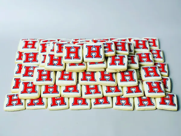Rows of square cookies iced with a red and navy varsity letter H