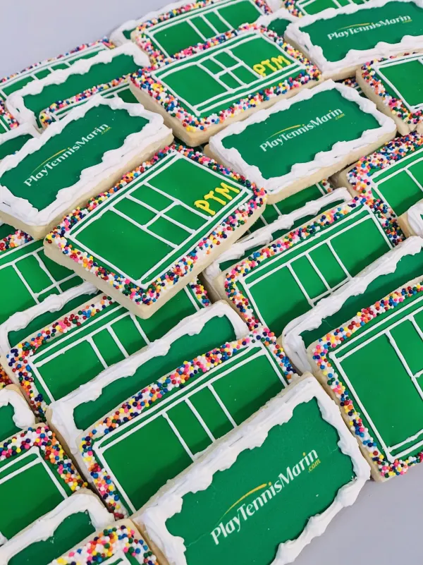 Green tennis court sugar cookies with sprinkle borders logoed PlayTennisMarin.com and PTM
