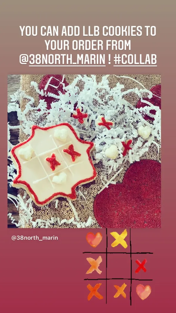 Tic-tac-toe cookie iced in white with a red sugar border and heart and X game pieces
