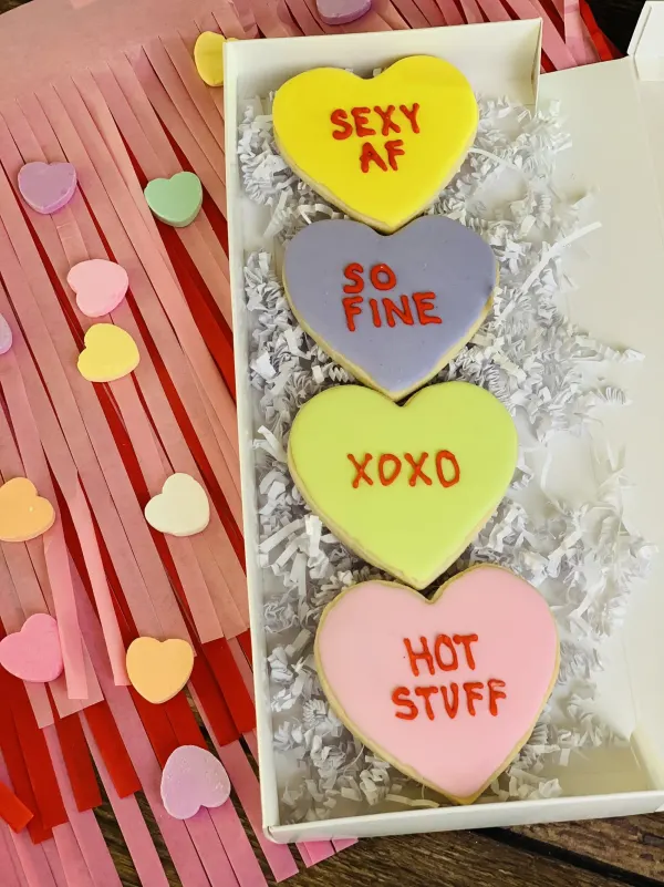 Boxed heart cookies lettered SO FINE, XOXO and HOT STUFF in red icing