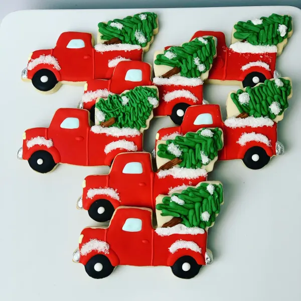 Red pickup truck cookies carrying piped green Christmas trees with sanding sugar snow
