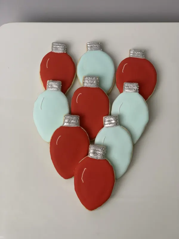 Christmas light bulb cookies iced in red and pale aqua with silver painted bases